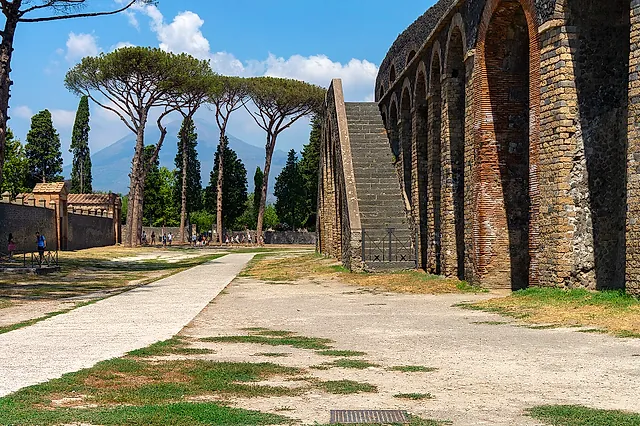 Los arcos exteriores y la escalinata del anfiteatro de Pompeya, con pinos piñoneros