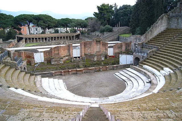 El Teatro Grande de Pompeya visto desde las gradas altas, con el edificio escénico y un pórtico detrás