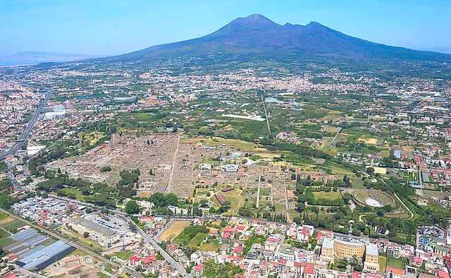 Vista aérea de las excavaciones de Pompeya y del Vesubio elevándose tras la llanura
